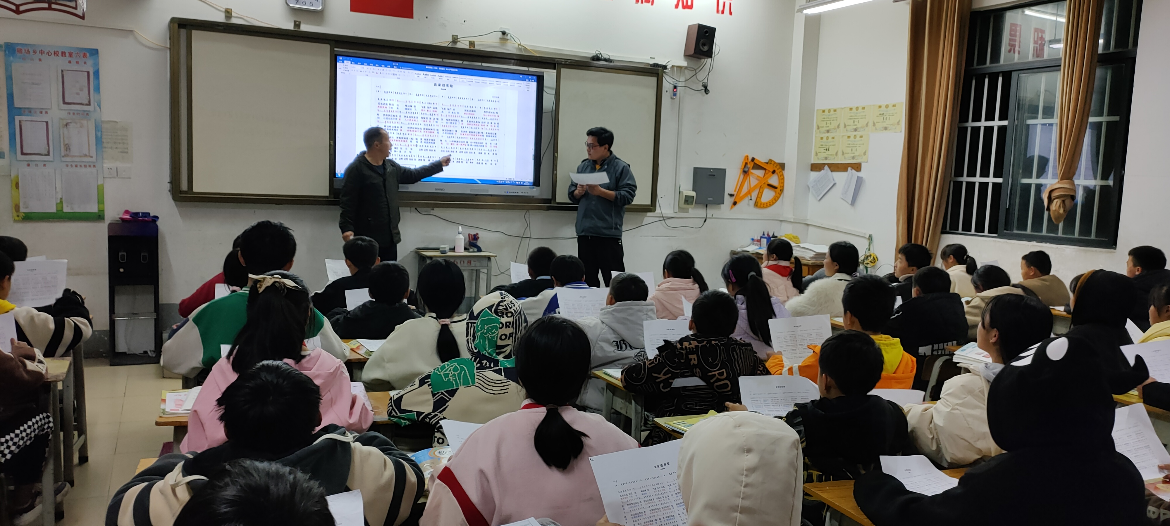 图为学校杨光杰主任耐心指导班级师生练习传唱家乡歌曲
